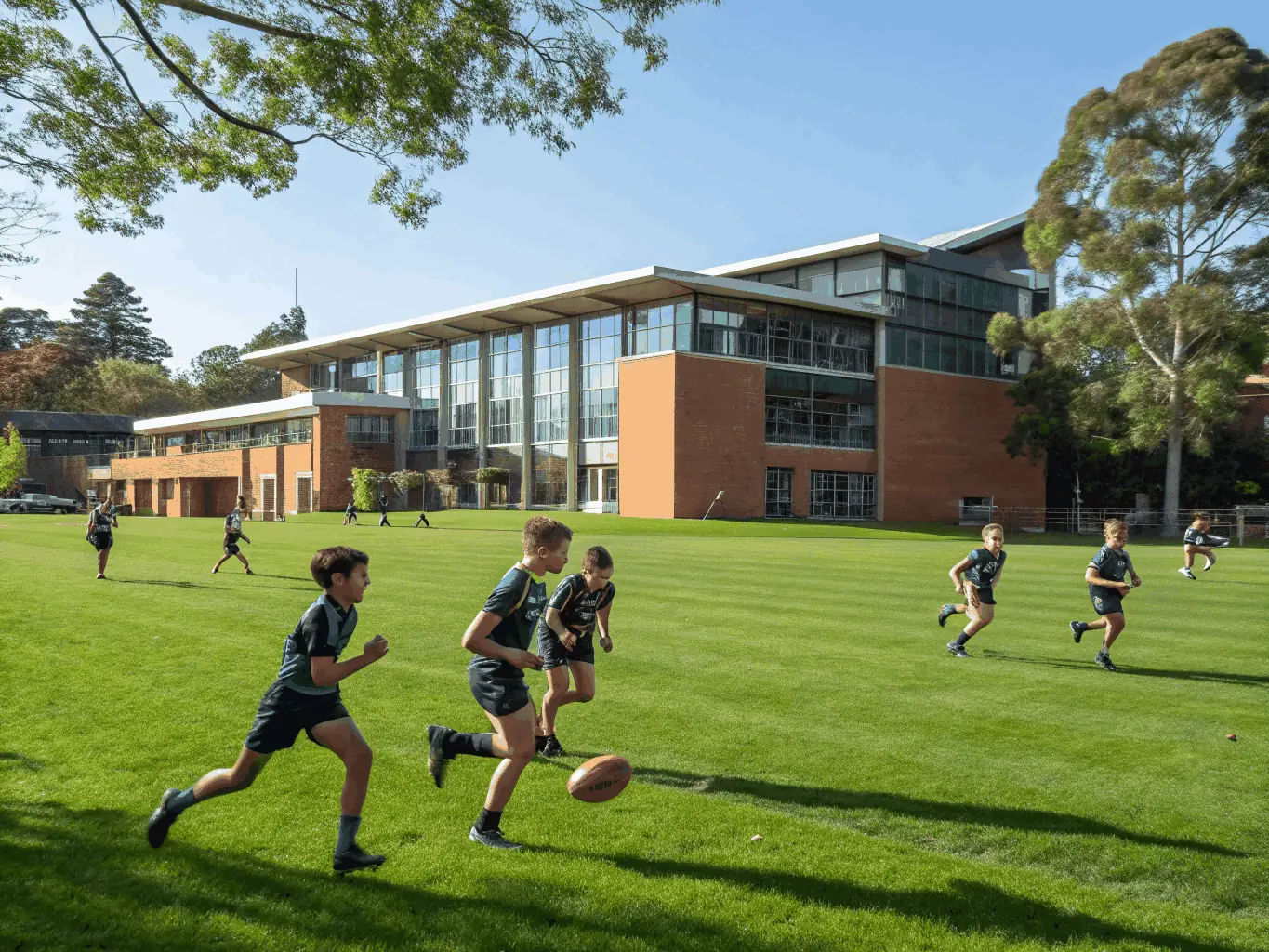 Students practicing their football skills on a well-maintained school field, emphasizing agility and sportsmanship.