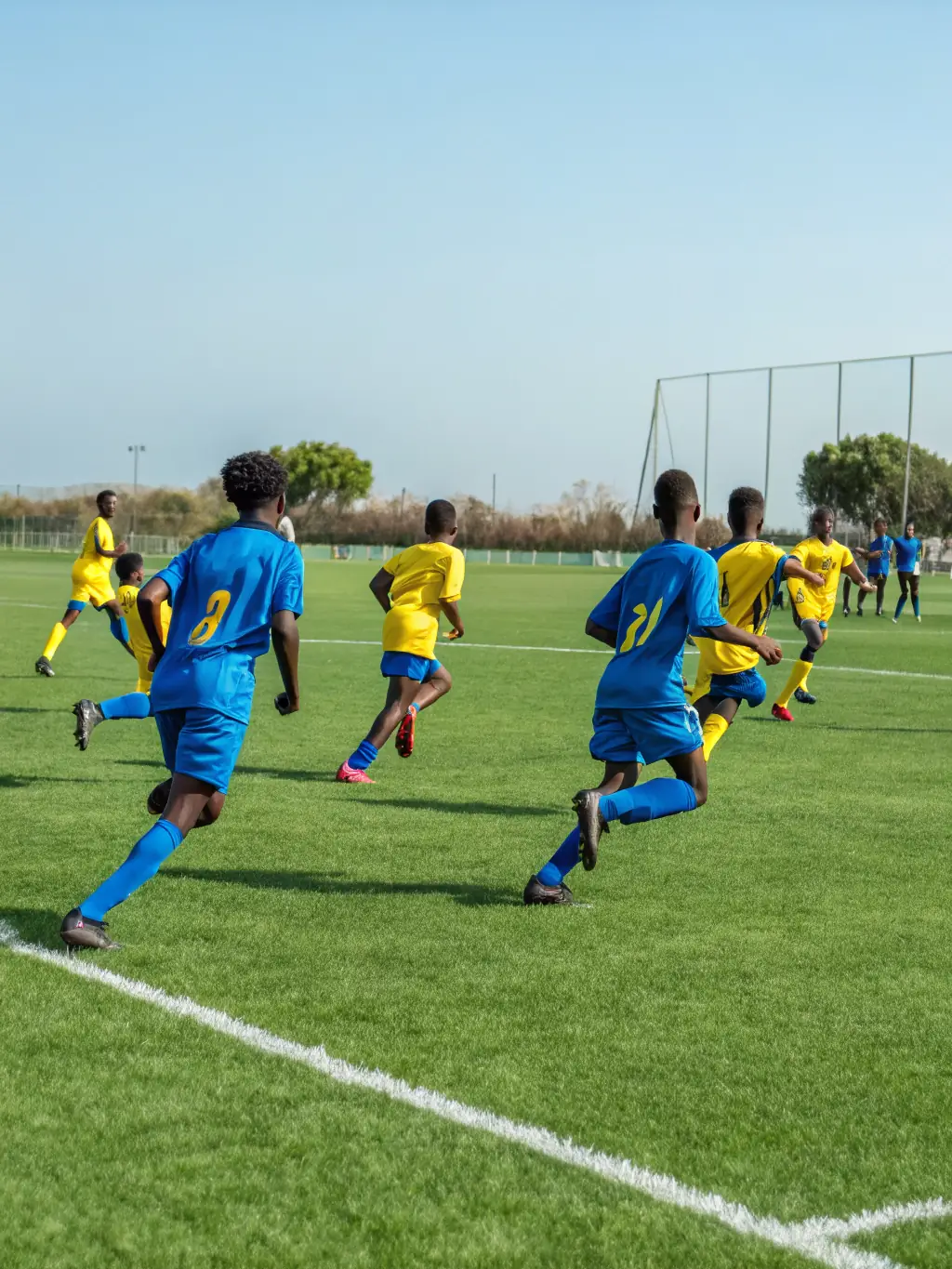 A group of students participating in a soccer match on a school field, showcasing their soccer skills and teamwork.